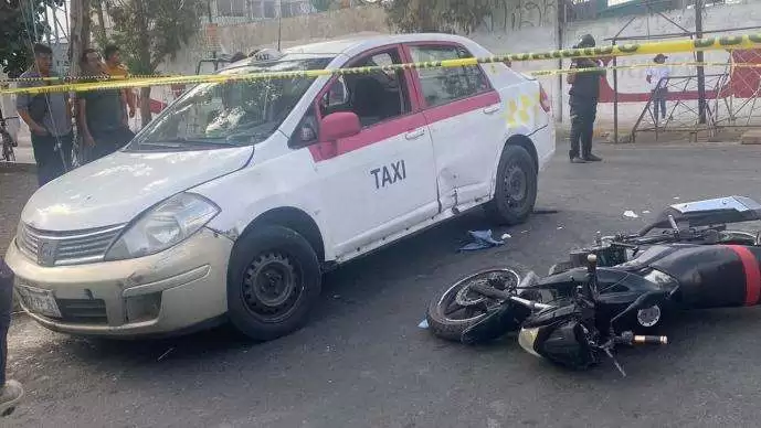 Mujer sin casco sale proyectada al ser impactada por un taxi en Neza